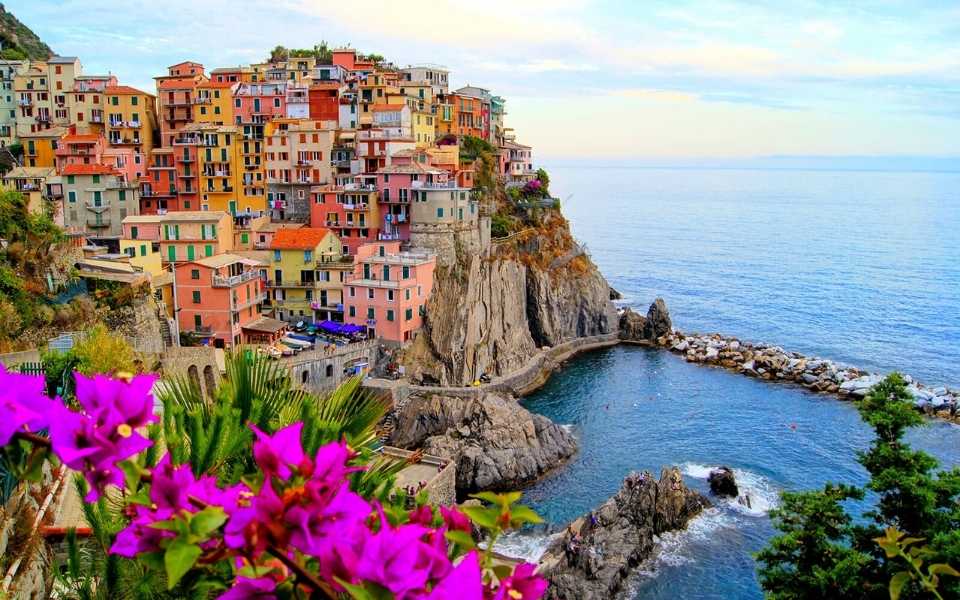 Beautiful picture of Italian village, Manarola, with the coast of Cinque Terre and flowers. Concept of European, Latin and Romance languages.