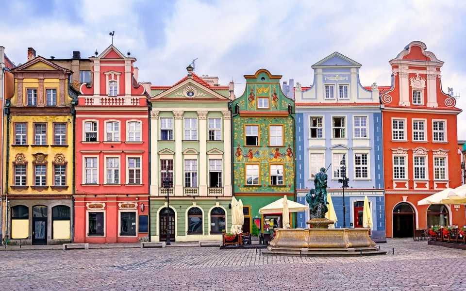 Renaissance coloured facades in a central square and a fountain in Poland. Concept of English into Polish translation.