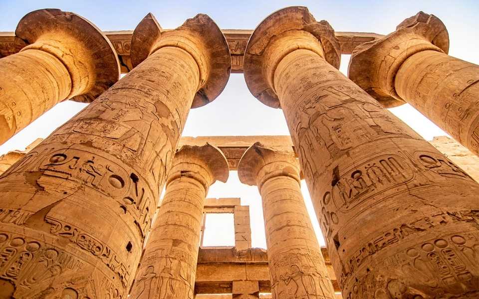 Colossal columns from the Pharaonic period engraved with hieroglyphs in Luxor, Egypt. Concept of Arabic translations.
