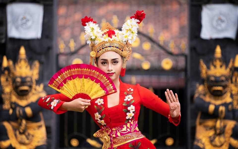 An Indonesian girl wears a traditional dress and dances a traditional dance. Concept of Indonesian translations.