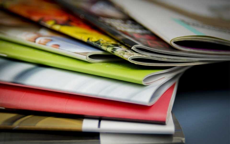 Some magazines with colourful covers. Concept of typesetting service.
