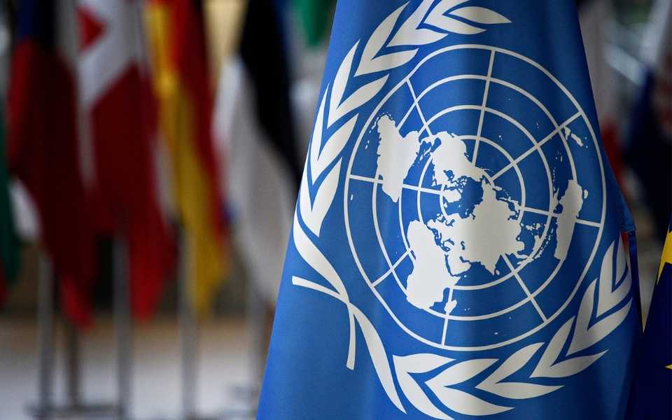 The flag of the United Nations and some other world flags behinds it. Concept of the languages of the United Nations.