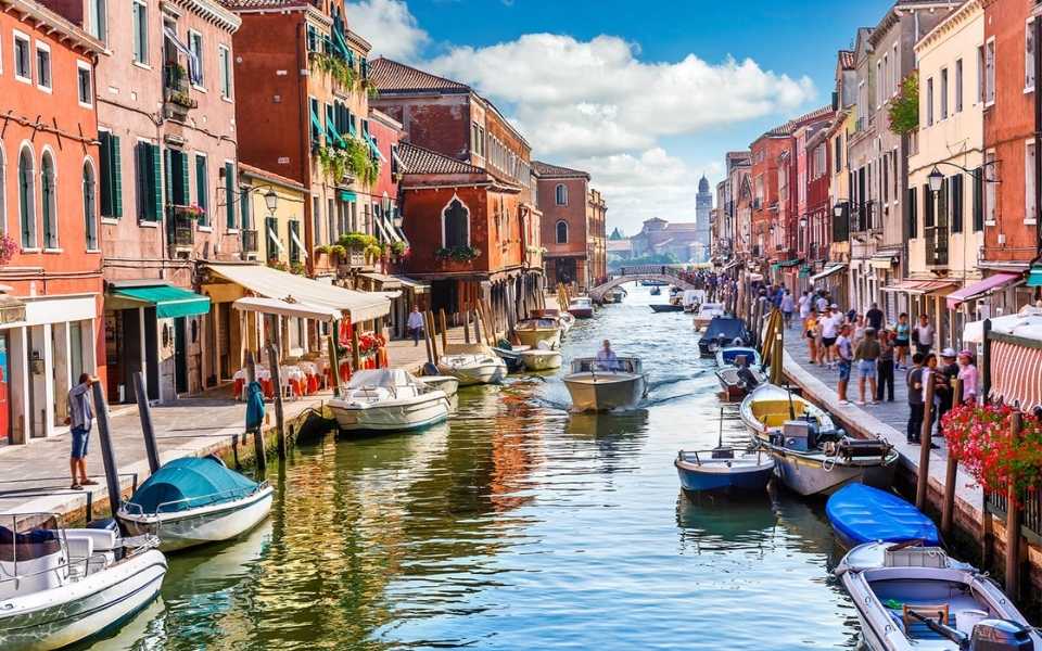 A canal in Venice, Italy with boats and buildings on its edge. Concept of Italian translations.