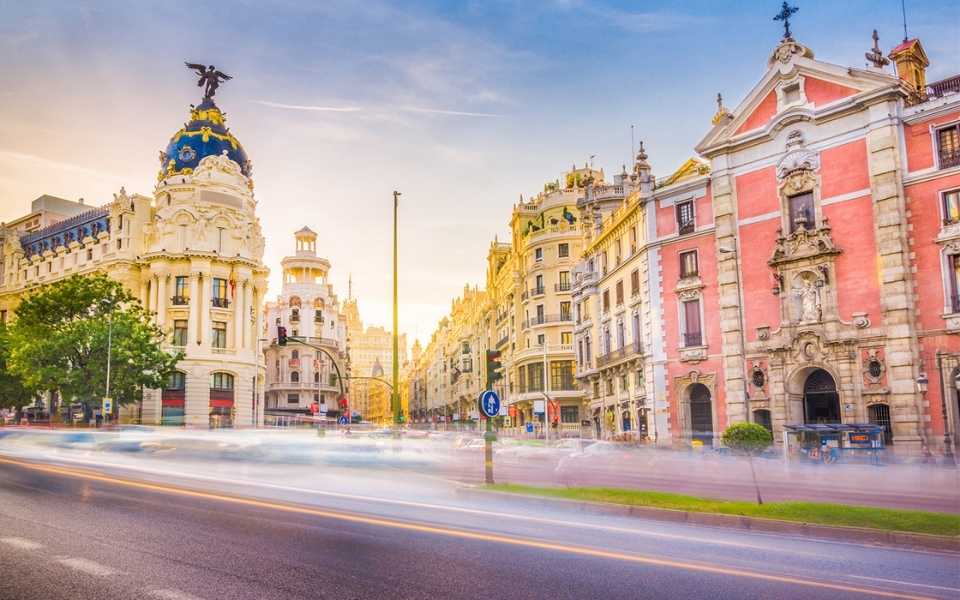 Metropolis Building in Madrid, Spain with high speed cars on the road. Concept of translation to Spanish. 