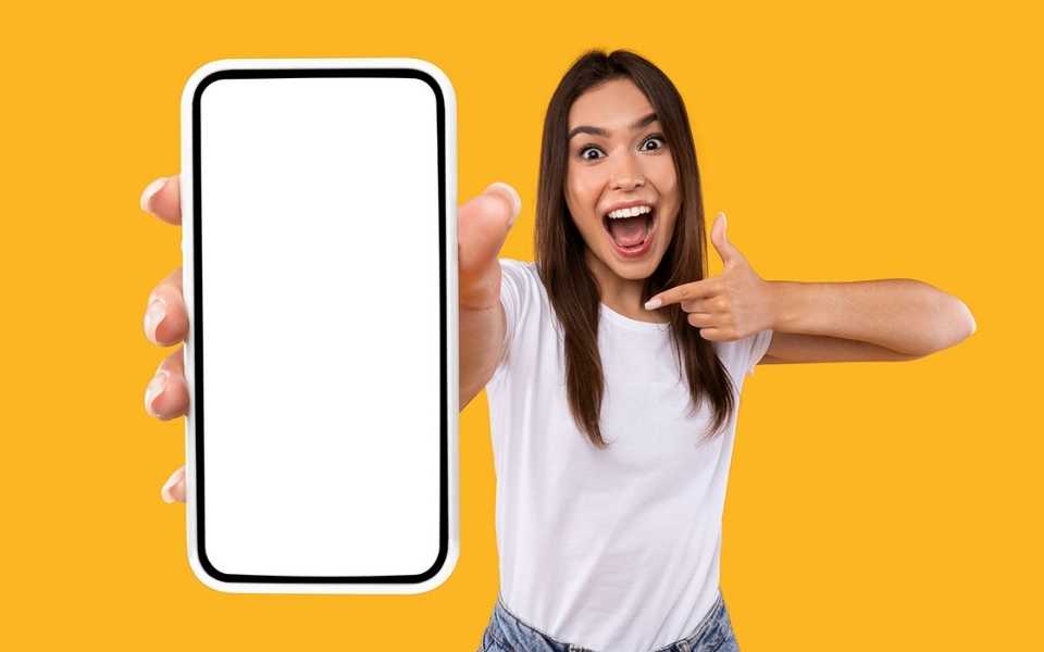 Happy asian woman holding a "white-screen" mobile with a yellow background. Concept of app translation.
