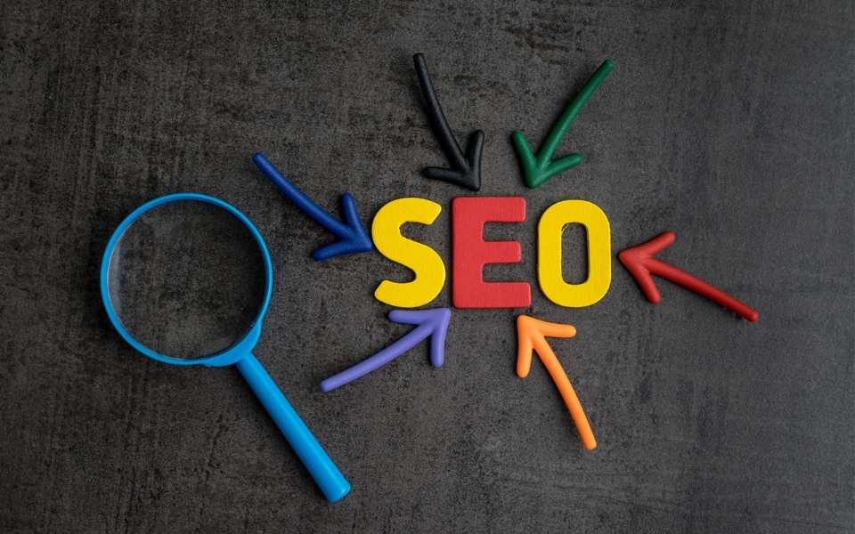 Arrows pointing at the word "SEO" with a magnifying glass beside it. Concept of SEO translations.