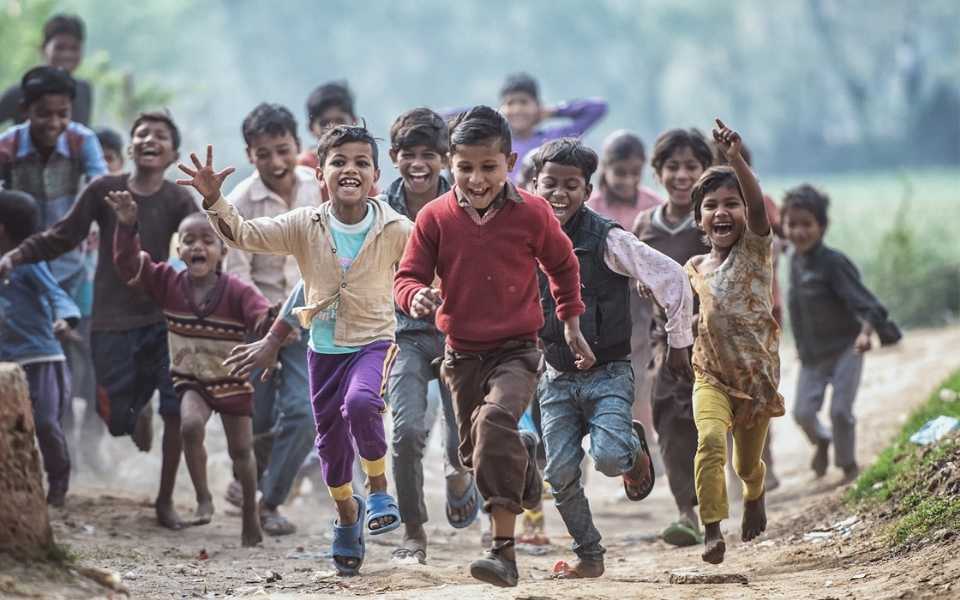A group of poor children running on a dirt road, barefoot. Concept of charity translation and professional charity translators.