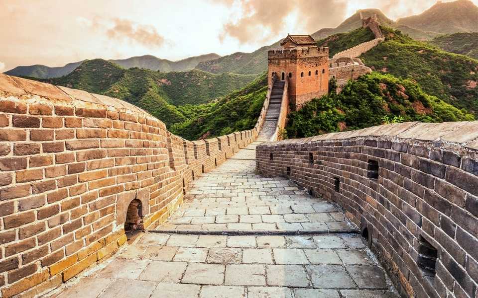 The Great Wall of China with sunset and trees appearing around it. Concept of Chinese language translation and professional translators.