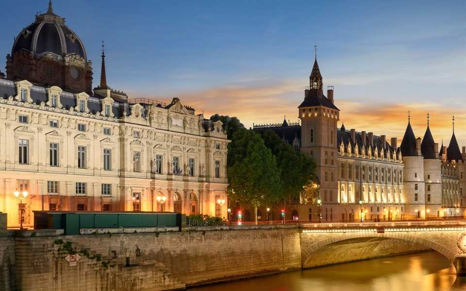 Conciergerie, Pont Neuf and Seine river at sunset in French capital, Paris. Concept of English to French translation.