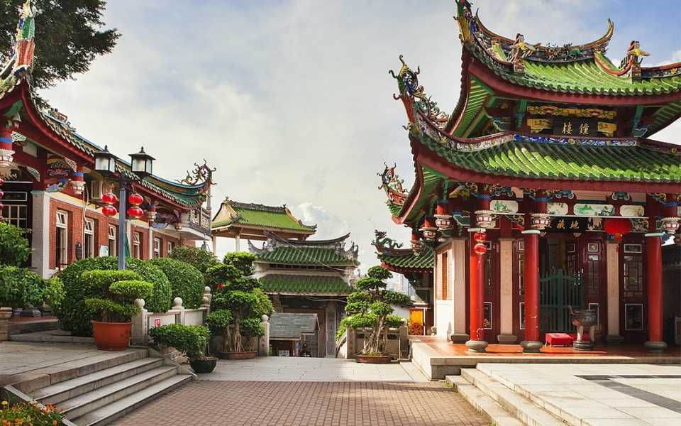 A temple in China contains colourful and decorated buildings, trees and lights. Concept of Mandarin translation services and Mandarin translators.