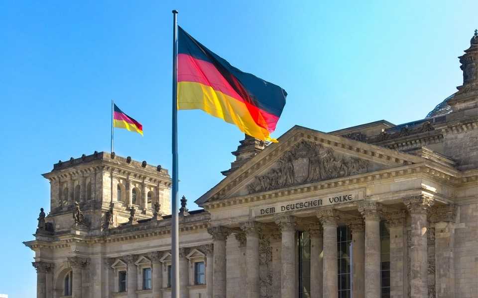 The flag of Germany at the top of Reichstag Building in Berlin. 