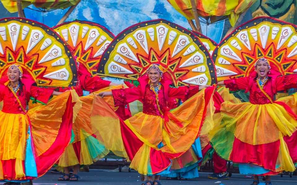 Filipino girls wearing colourful dresses at a festival in the Philippines. Concept of English to Filipino translation.