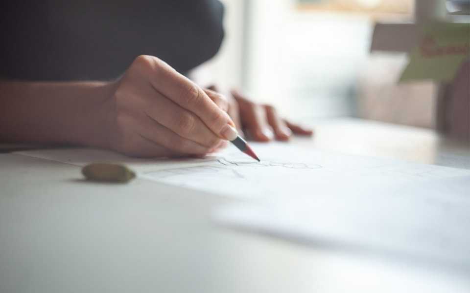 A woman's hand writes something with a pencil. Concept of accurate translations.