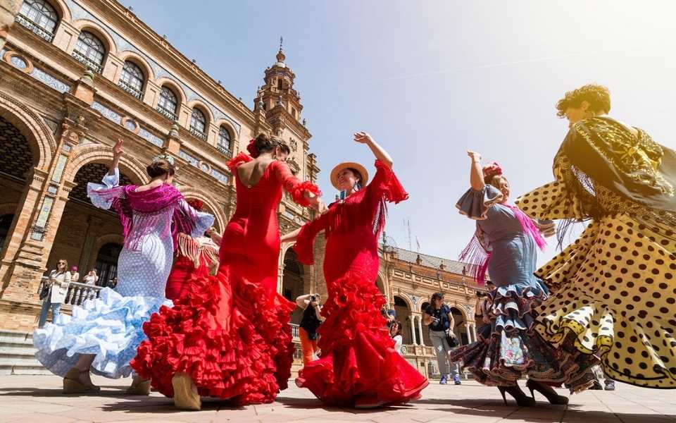 Traditionally dressed Spanish women performing in the square of a Spanish city. Concept of Spanish translations.
