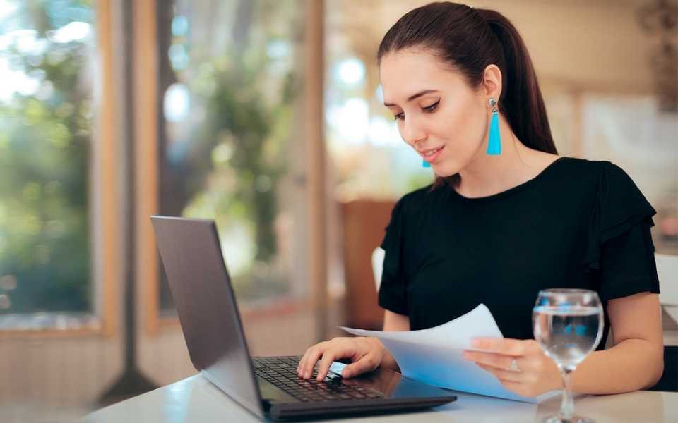 A women sitting at her workplace in front of a computer. Concept of audio transcription services.