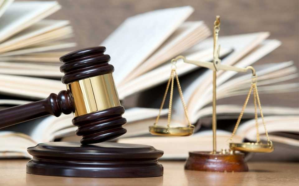 A judge's gavel on a wooden table with books behind it. Concept of official and certified legal document translations.