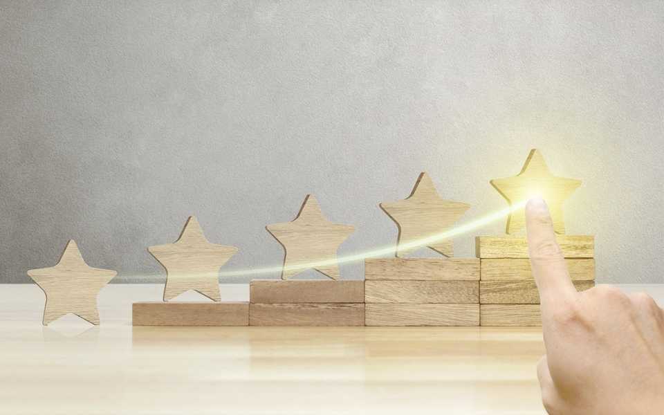 Five wooden stars, a man chooses the right, and it lights up. Concept of document translation services in the UK.
