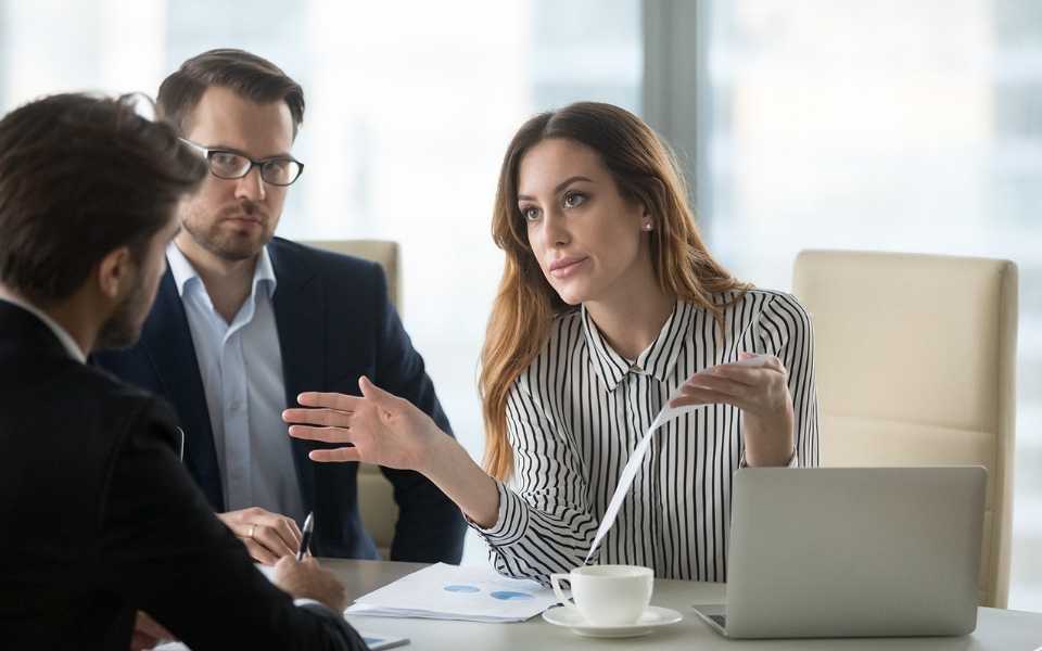 A man and a woman, holding some paper, talking to another man. Concept of professional freelance translators working online.