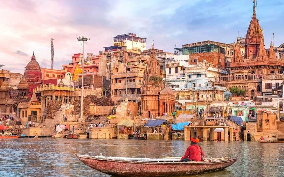 An Indian man on a boat in a river in Varanasi City, India. Concept of English to Hindi translation.