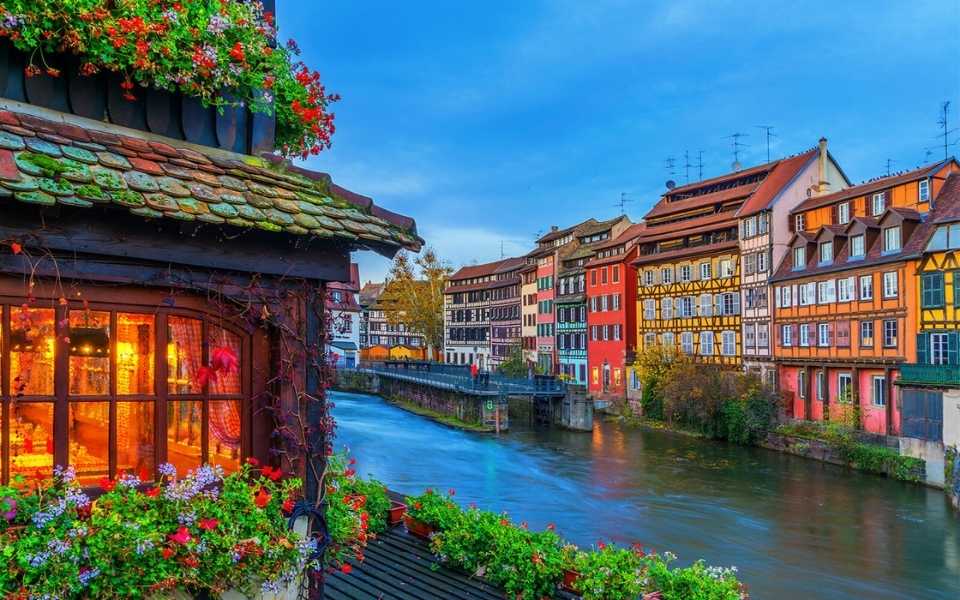 Colourful buildings on the bank of a river in Strasbourg, Alsace, France. Concept of the French language.