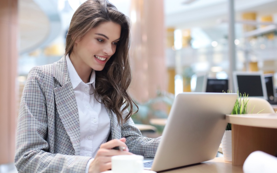 A pretty female employee is handling urgent translation services while working in office.