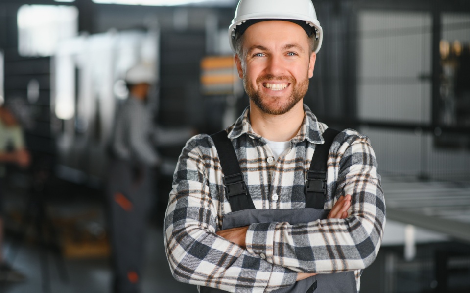Male worker wearing a white helmet at a factory. Plastics industry technical translation. 