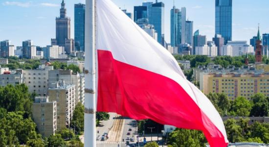 Flag of Poland and business skyscrapers in the background.