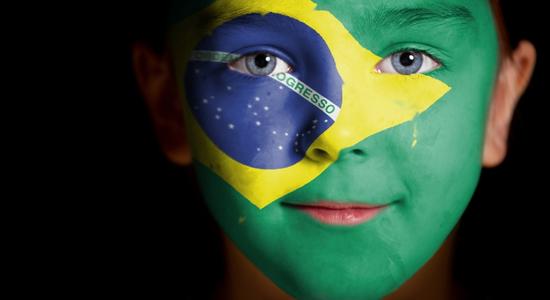 Portrait image of a child with Brazil's flag painted on his face.
