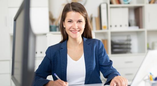 Smart female office employee working with laptop and documents. Concept of Dutch translators.