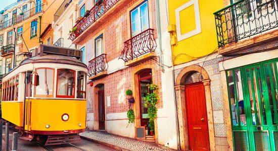 A Portuguese street with colorful houses and a yellow tram. Concept of technical Portuguese translation.
