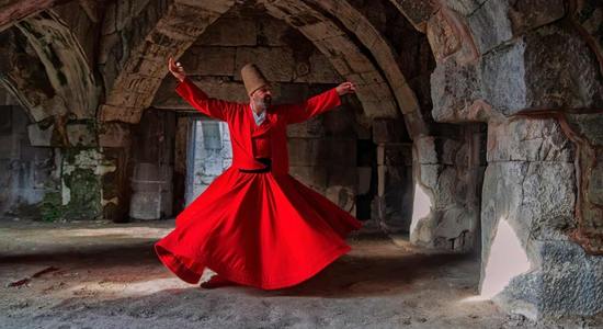 A Turkish man in red, traditional Sufi dress. Concept of professional Turkish translators.