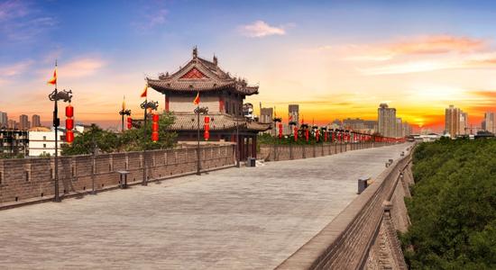 Fortifications of Xi'an with a path in the front, at sunset. Concept of English to Chinese translation.