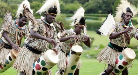 Four men performing African traditional folk dance.