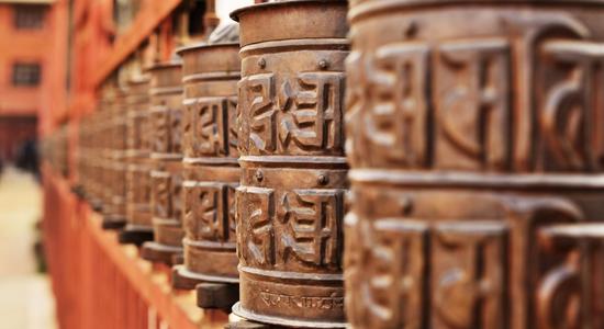 Praying drums with Sanskrit symbols. Concept of Sanskrit translation services.