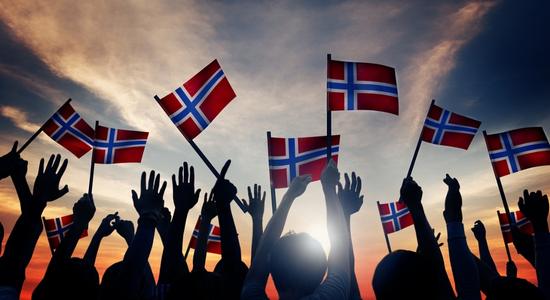 Backlit silhouttes of people waving Norwegian flags. Concept of professional Norwegian translators.
