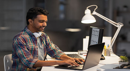 Bengali man working on computer in office. Concept of legal Bengali translation. . 