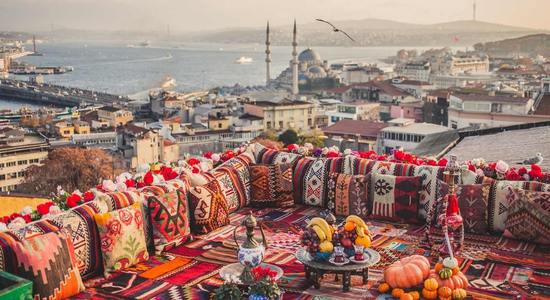 A red seating area overlooking Istanbul and a large mosque.