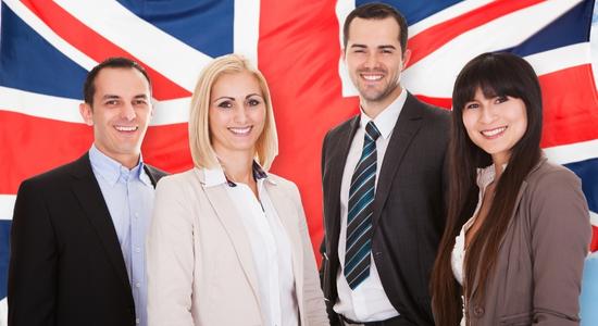 A group of British professionals standing with the British flag in the background. Concept of English translators.