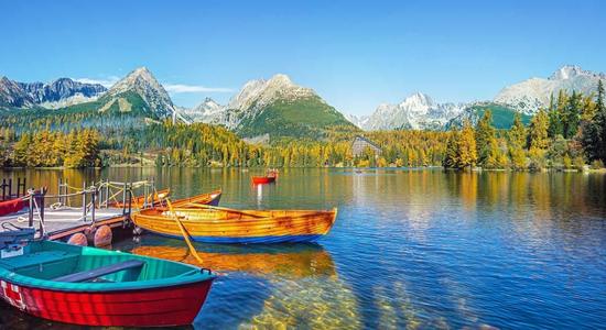 Strbske lake with a rowing boat, mountains in the distance. 