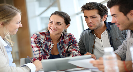 A group of young people sitting on table and discussing business. Concept of professional Portuguese translators.