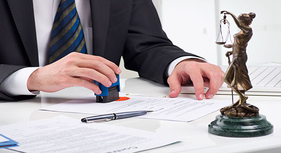 A certified lawyer stamping a document in office. Concept of Urdu legal document translation. 