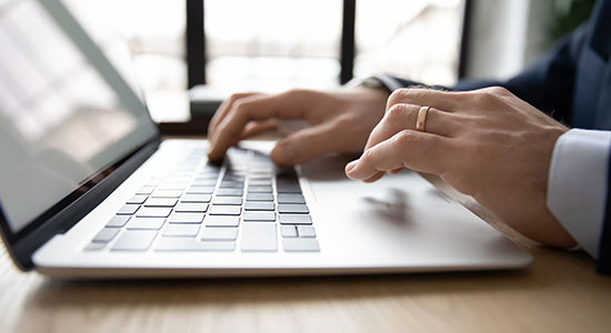 Man hands typing on laptop's keyboard. Concept of Hungarian translators. 