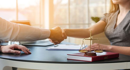 Man and woman shaking hands in a law office. Concept of legal Ukrainian translation.