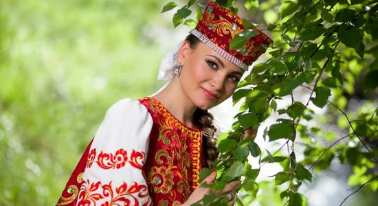 A smiling woman in red, traditional Russian clothes. Concept of professional Russian translators.