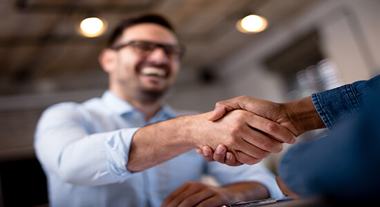 Two businessmen shaking hands in office. 