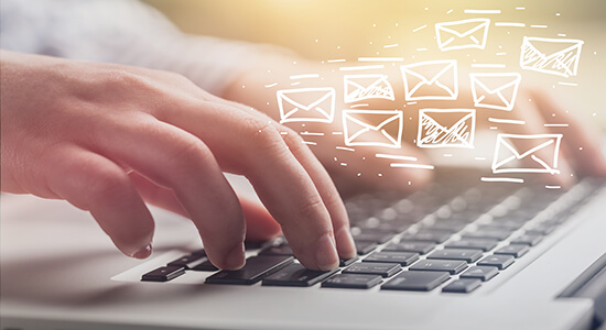Woman hands typing on keyboard with email icons.