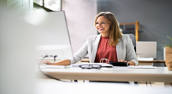 Happy and professional woman working on computer. Concept of Polish translators.