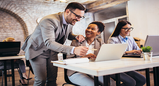 Two woman at office taking an advice from a senior male employee.