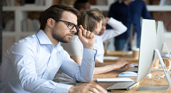 Highly focused male employee working in an office. 