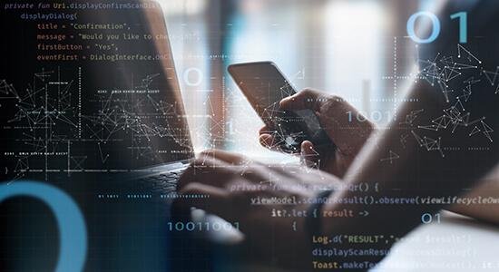 Male website developer holding mobile phone and working with computer.